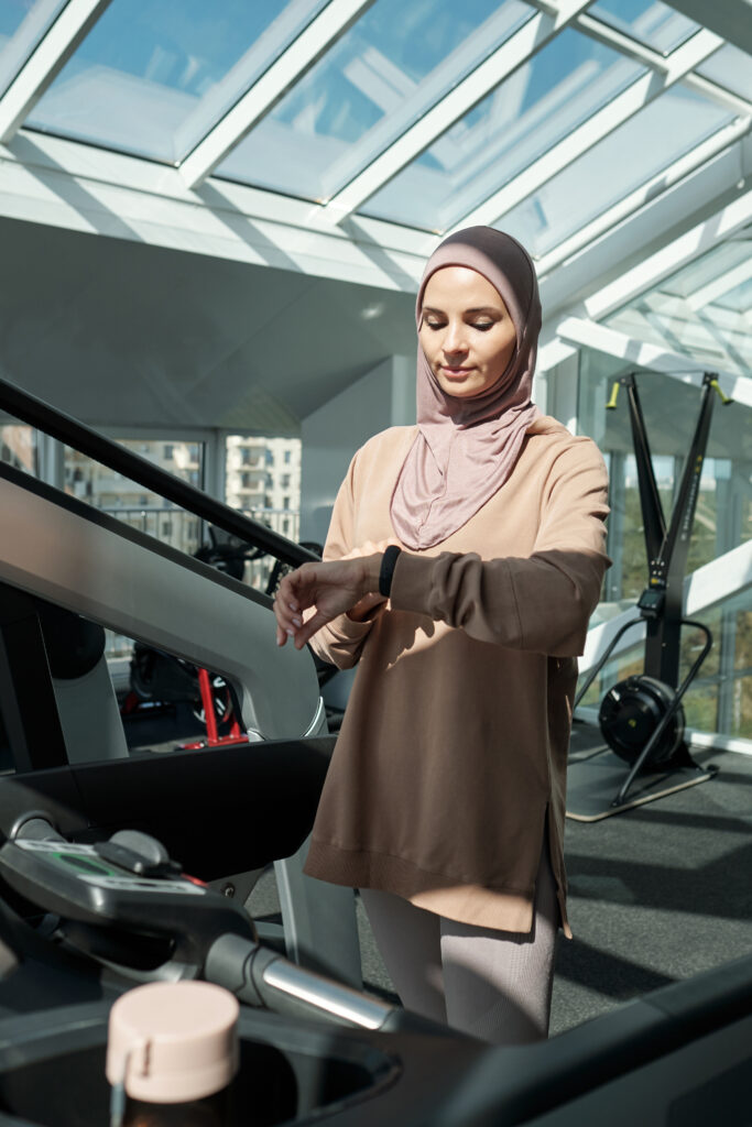 Woman looking at fitness tracker while in a gym